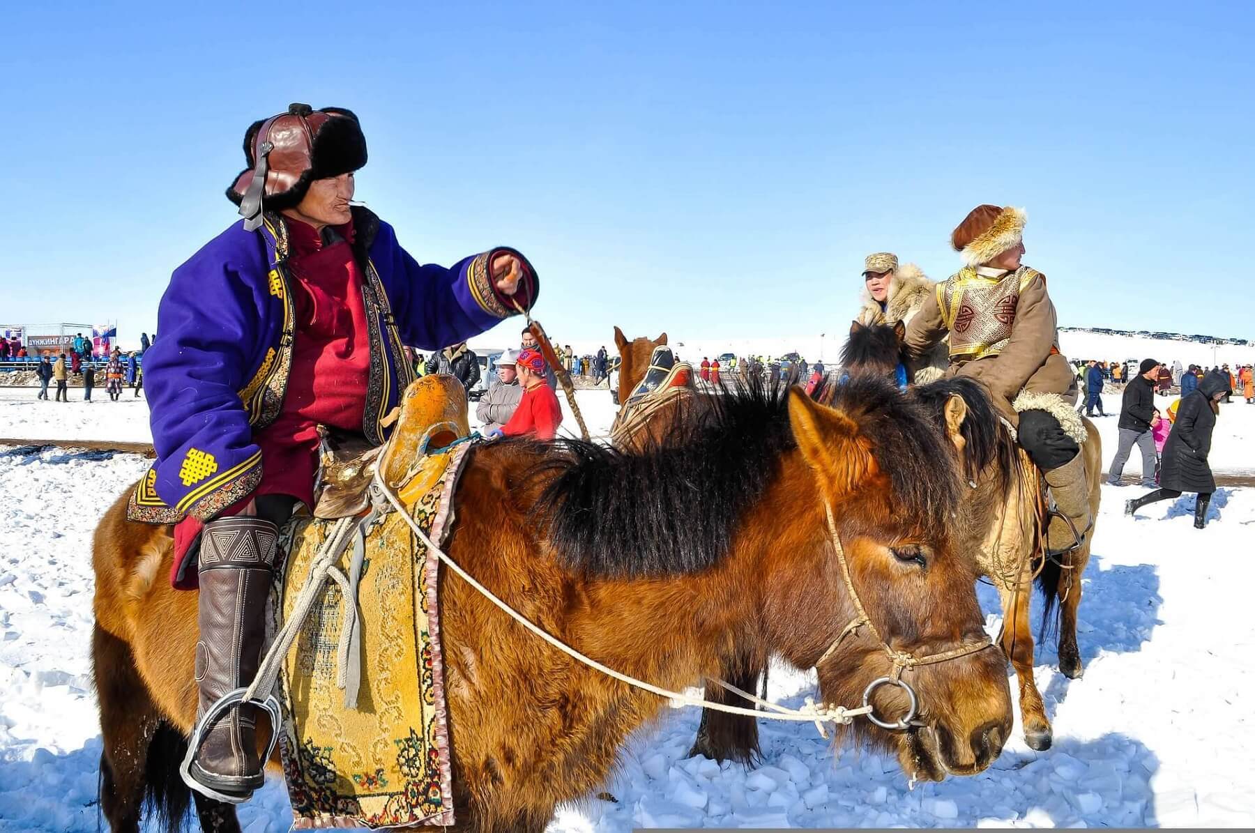 mongolian man riding a horse in winter